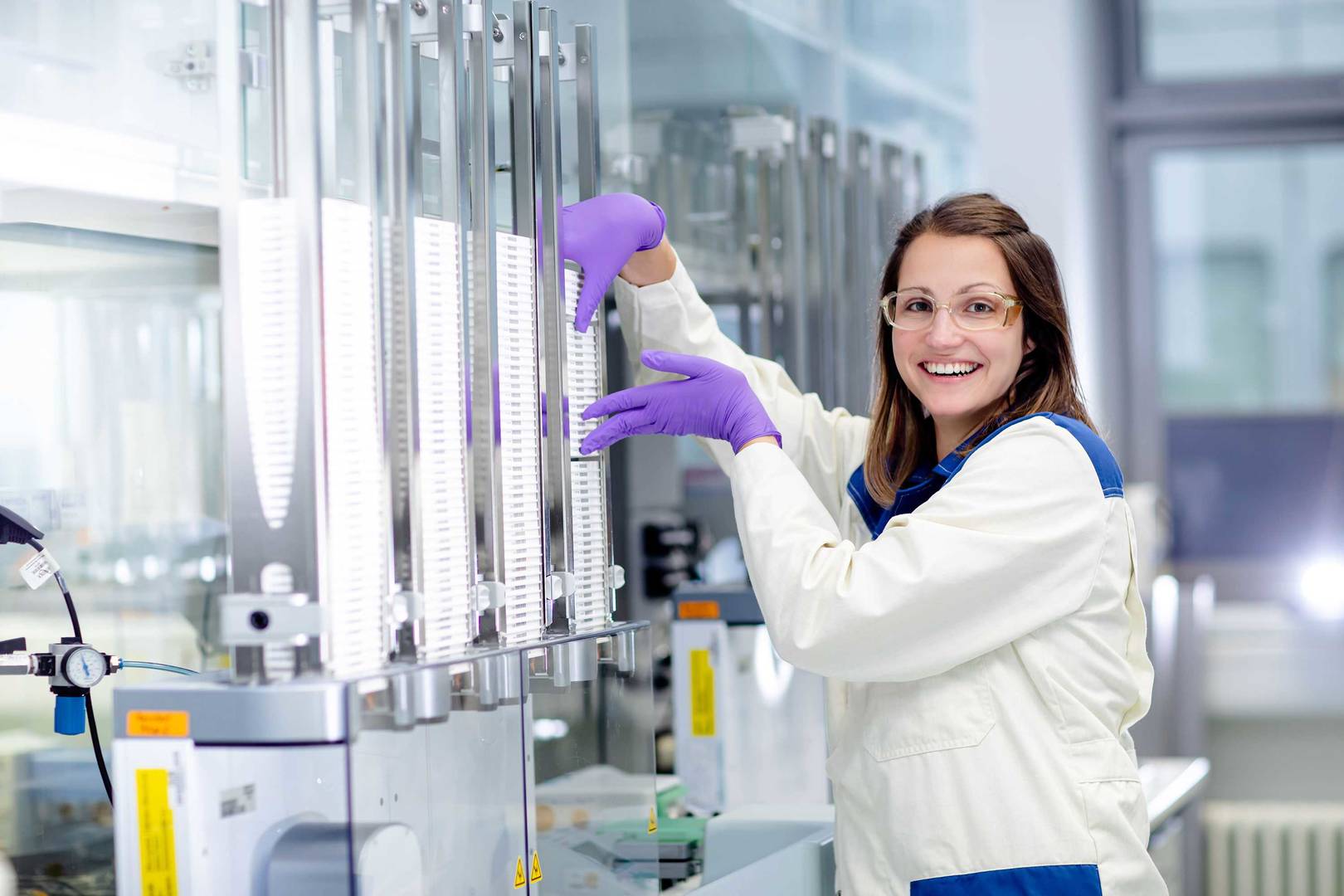 Screening expert processing a stack of assay plates